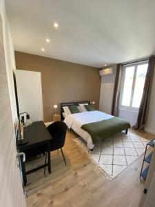 a bedroom with a bed and a desk and a desk at Appartement La Maouin 2 pièces in Saint-Laurent-du-Var