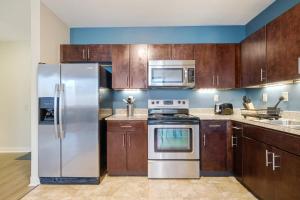 a kitchen with wooden cabinets and stainless steel appliances at Vibrant Luxury PRIME LOCATION 24-7 Onsite Parking Gym Lounge in Pittsburgh