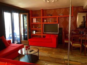 a living room with a red couch and a tv at Argostoli`s Heard in Argostoli