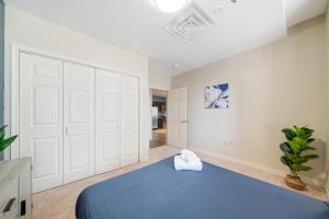 sypialnia z niebieskim łóżkiem i białą ścianą w obiekcie 1B1B Vibrant Luxury Valet Gym Lounge Roku w mieście Pittsburgh