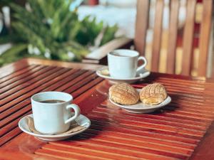 two cups of coffee and cookies on a wooden table at La Casa de las Lunas in Chichén-Itzá