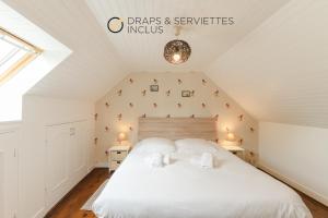 a bedroom with a white bed in a attic at ERRAGOUNAN - Joli gîte rural près du golf in Plouarzel