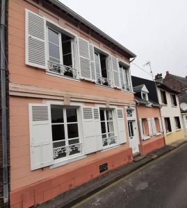 a building with white shuttered windows on a street at ED22 L'Eudoise grande maison de ville in Eu