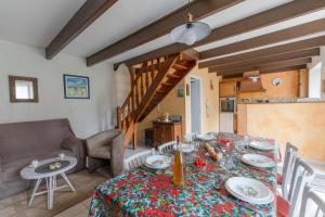 a dining room with a table and a couch at ERRAGOUNAN - Joli gîte rural près du golf in Plouarzel +42 photos
