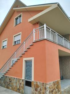 una casa arancione con le scale sopra di CasaLuaces a Ribadeo