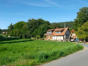 una casa su un campo verde vicino a una strada di Ferienhaus mit Garten im Odenwald zu vermieten a Fränkisch-Crumbach