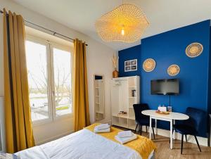 1 dormitorio con cama, mesa y ventana en Le Quai Saint Laurent - BY PRIMO C0NCIERGERIE, en Orléans