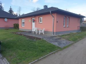 a pink house with a table and chairs in front of it at Ferienhaus Siggi in Walow
