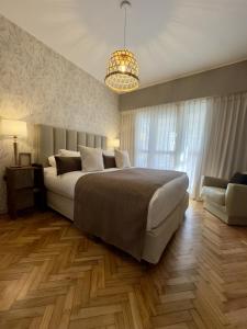 um quarto com uma cama grande e um lustre em Hotel Facon Grande em Buenos Aires