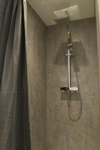 a shower with a shower curtain in a bathroom at The Almshouse Suites in Woburn Sands
