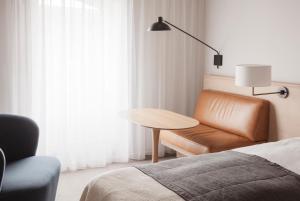 1 dormitorio con sofá, mesa y silla en Copenhagen Admiral Hotel, en Copenhague