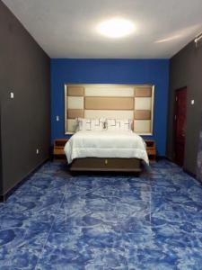 1 dormitorio con 1 cama grande, paredes azules y suelo azul en HOTEL COMFORT, en Quelimane