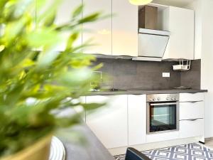 uma cozinha com armários brancos e um fogão em Comfy Apartment mit Garten in Köln em Colônia