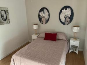 ein Schlafzimmer mit einem Bett und zwei Bildern an der Wand in der Unterkunft El Ático de los Girondinos in Cádiz