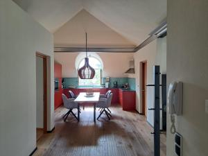 uma cozinha com mesa e cadeiras num quarto em Mansarde Zeder in Privatvilla im Zentrum Merans em Merano