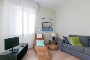 a living room with a couch and a tv at Condominio Secchiati in Lido di Jesolo