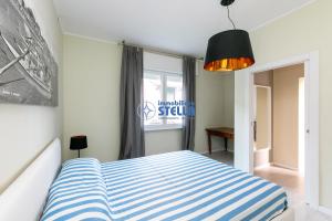 1 dormitorio con cama de rayas azul y blanco en Condominio Secchiati en Lido di Jesolo