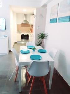 a white table with white chairs and a white kitchen at Paraíso de la Costa Brava in Portbou