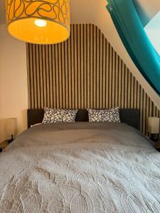 a bedroom with a bed and a chandelier at Gemütliche Dachgeschosswohnung mit Stellplatz - R9-DGr in Lohfelden
