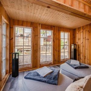 two beds in a room with wooden walls and windows at Seebär in Ueckeritz