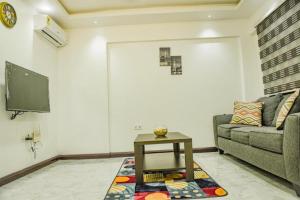 a living room with a couch and a tv at Impeccable 1-Bed Airbnb in Borteyman in Kwedonu