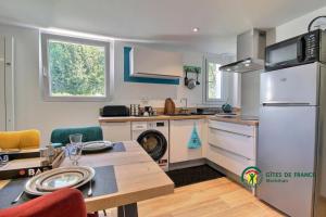 een keuken met een koelkast en een tafel. bij La Fleur de Vie in Pluneret +8 foto's