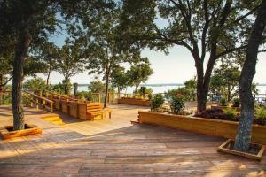 a park with wooden benches and trees and water at Restaurants, Bars, Lake & Trails near DFW Airport in Flower Mound