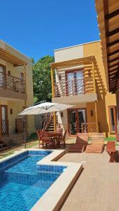 a villa with a swimming pool and a house at Zaya Beach Residence in Icaraí