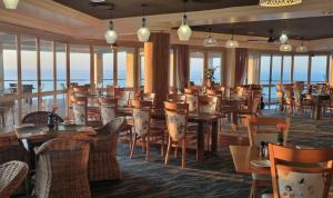 a restaurant with tables and chairs and the ocean in the background at Pinnacle Lodge 1089 in Dana Bay