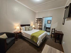 sypialnia z łóżkiem, kanapą i telewizorem w obiekcie Aloes 1st on Camp w mieście Middelburg