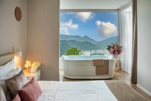 a bedroom with a tub and a view of a mountain at Rota Suites in Rota d'Imagna