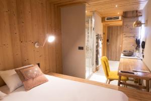 a bedroom with a bed and a desk and a table at La maison rouge 3* in Barberaz