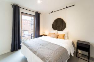 a bedroom with a large bed and a large window at Beautiful 1BR apartment in Antwerp in Antwerp +7 photos