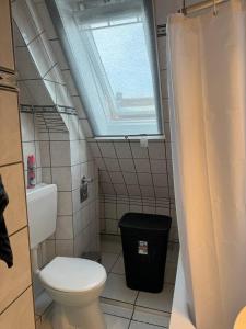 a small bathroom with a toilet and a window at Gemütliche Dachgeschosswohnung mit Stellplatz - R9-DGr in Lohfelden