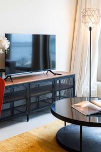 a living room with a table and a television at Beautiful 1BR apartment in Antwerp in Antwerp