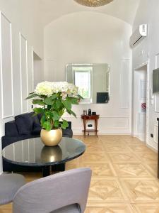 a living room with a table with a vase of flowers at Fiorentine Relais in Naples