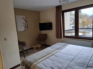 a bedroom with a bed and a window and a tv at Au Coeur d'Alle in Alle +29 photos