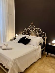 a bedroom with a large white bed with a metal headboard at Fiorentine Relais in Naples