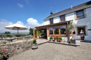 an external view of a house with an umbrella at Castle Reach Newport, Pembrokeshire in Newport Pembrokeshire