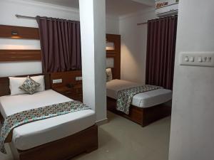 a small room with two beds in it at Rieva Residency in Kottayam