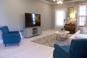 a living room with a couch and a tv at Country Cottage - Broussard in Broussard
