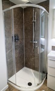 y baño con ducha y mampara de cristal. en Modern 2 Bedroom Home in Edinburgh Free Parking, en Edimburgo