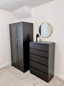 a black dresser and a mirror in a room at Modern 2 Bedroom Home in Edinburgh Free Parking in Edinburgh