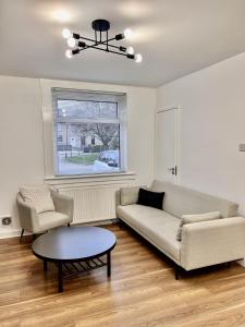 uma sala de estar com um sofá e uma mesa em Modern 2 Bedroom Home in Edinburgh Free Parking em Edimburgo