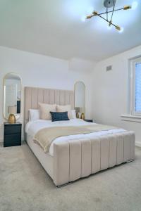 1 dormitorio grande de color blanco con 1 cama blanca grande y una gran colcha blanca en Modern 2 Bedroom Home in Edinburgh Free Parking en Edimburgo