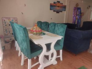 uma mesa com cadeiras verdes e uma mesa com um candeeiro em Cozy Homestay Private Room: Home-Away-Home em Addis Ababa
