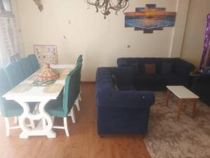 uma sala de estar com um sofá azul e uma mesa em Cozy Homestay Private Room: Home-Away-Home em Addis Ababa