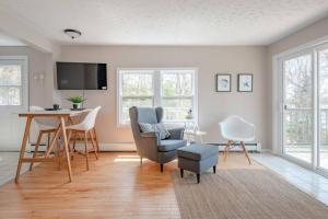 uma sala de estar com uma secretária, cadeiras e uma mesa em Dreamy Lakefront View Retreat House on Melissa Ave em Terence Bay