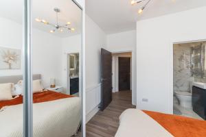 1 dormitorio con cama y espejo en 2 Bed Exceptional Stay, en Reading