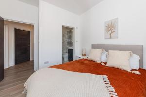 a white bedroom with a large bed with white pillows at 2 Bed Exceptional Stay in Reading